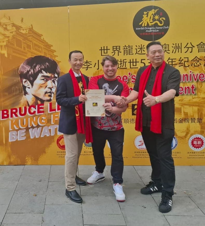 Sensei Brendon receiving a certificate of appreciation at the Bruce Lee 53rd anniversary event